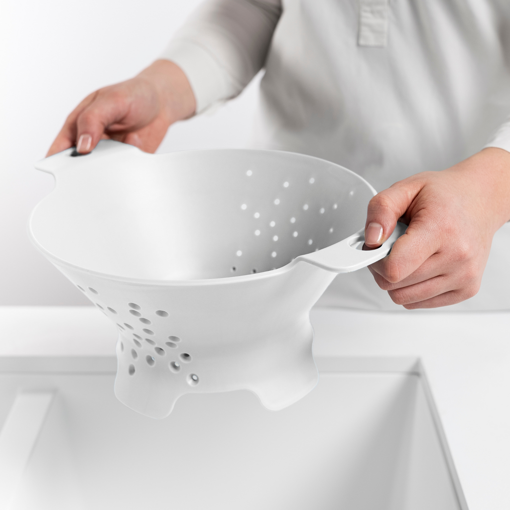 Blim+ Cosmo Colander Medium in white, held over a sink