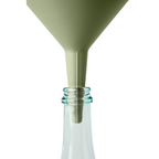 Blim+ Dolina Funnel in green, placed in a glass bottle