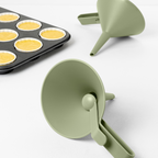 Blim+ Dolina Funnel in green, beside a muffin tray