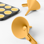 Blim+ Dolina Funnel in yellow, beside a muffin tray