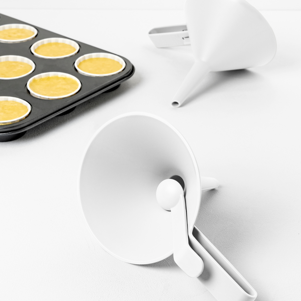 Blim+ Dolina Funnel in white, beside a muffin tray