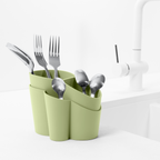 Blim+ Gocciolo Cutlery Drainer in green, holding cutlery beside a tap