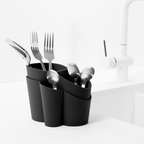 Blim+ Gocciolo Cutlery Drainer in black, holding cutlery beside a tap
