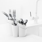 Blim+ Gocciolo Cutlery Drainer in white, holding cutlery beside a tap