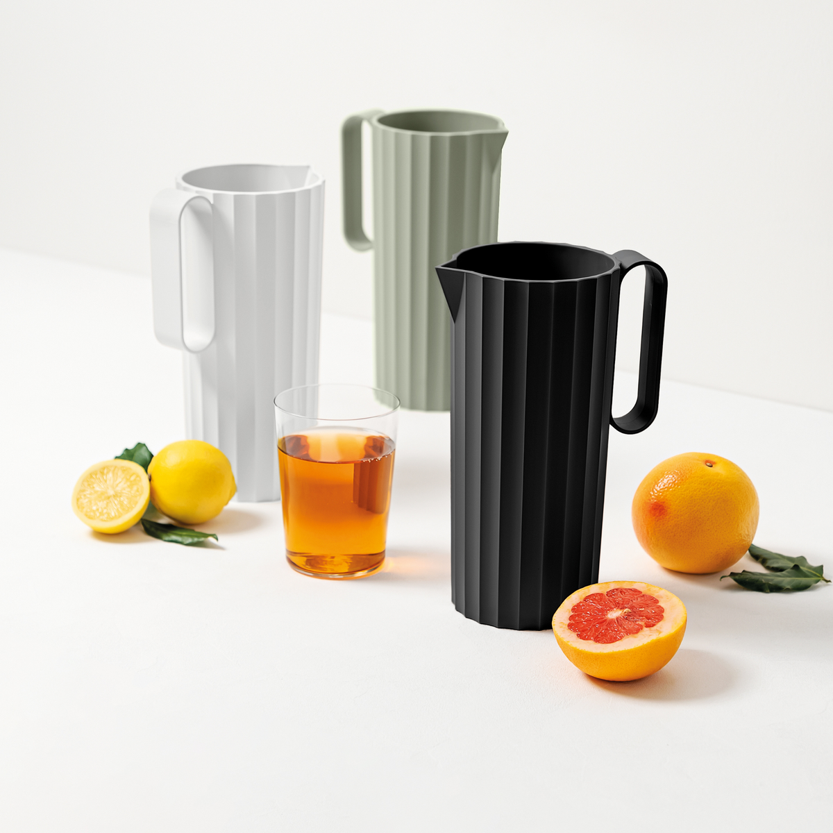 Blim+ Carafe Hydria in white, green and black beside glasses of iced drink and citrus fruit