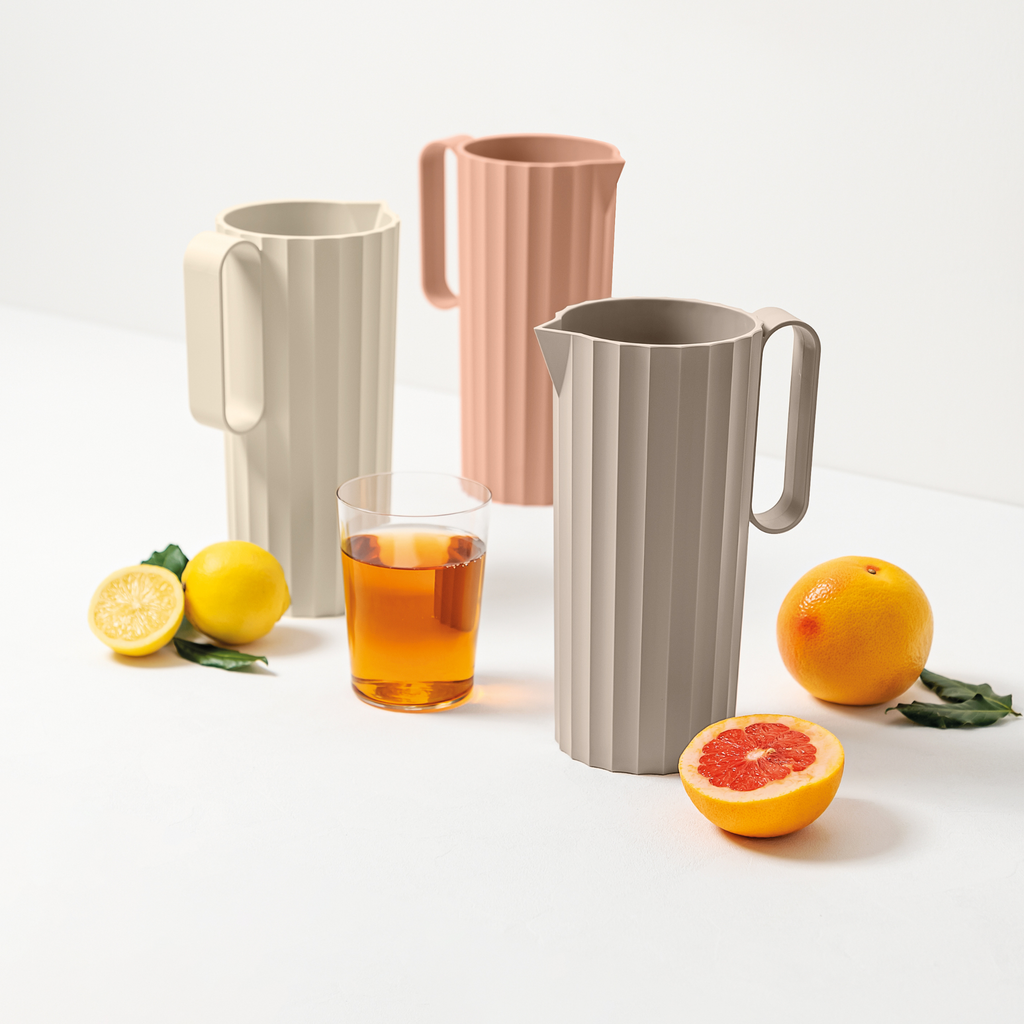 Blim+ Carafe Hydria in taupe, pink and cream beside glasses of iced drink and citrus fruit
