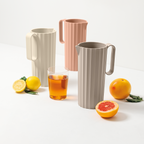 Blim+ Carafe Hydria in taupe, pink and cream beside glasses of iced drink and citrus fruit