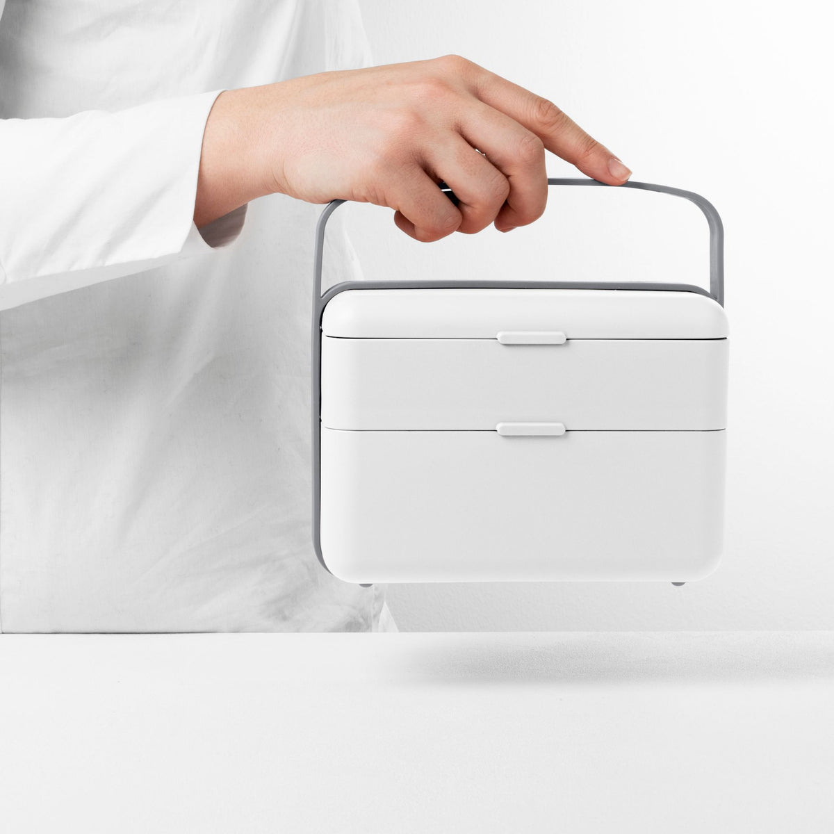 Blim+ Lunchbox Bauletto Medium in white, carried by the handle
