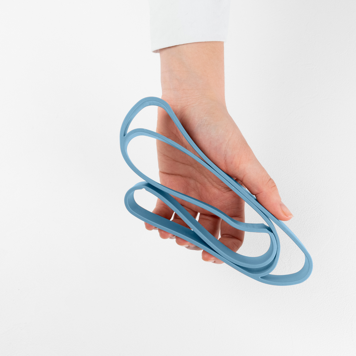 Blim+ Lunchbox Bauletto Small with a blue elastic strap held in a hand