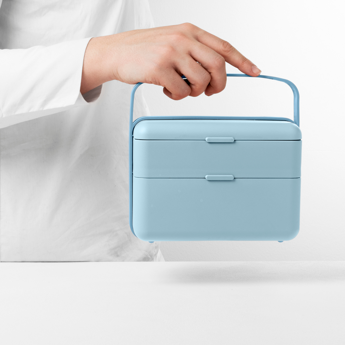 Blim+ Lunchbox Bauletto Medium in blue, carried by the handle