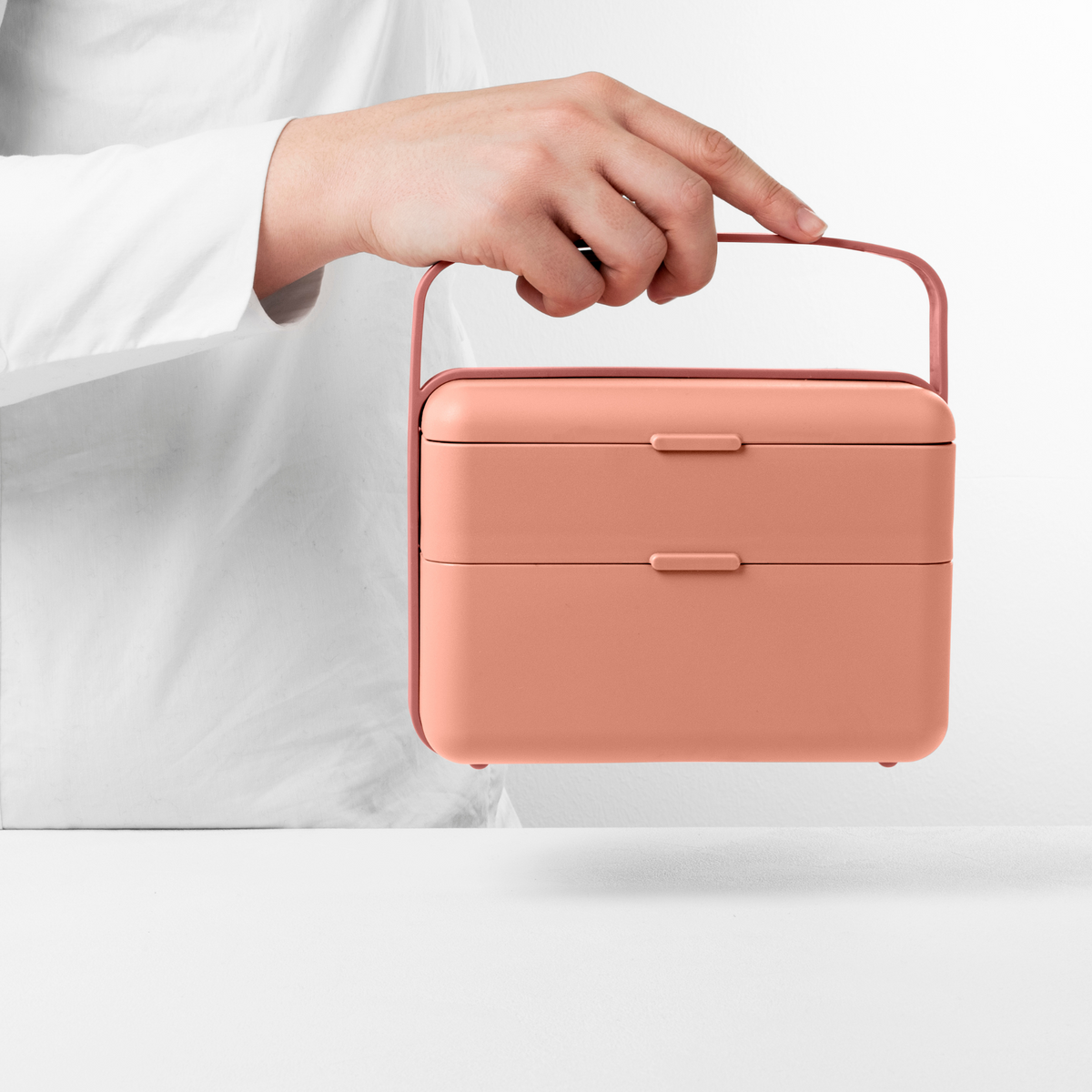 Blim+ Lunchbox Bauletto Medium in pink, carried by the handle