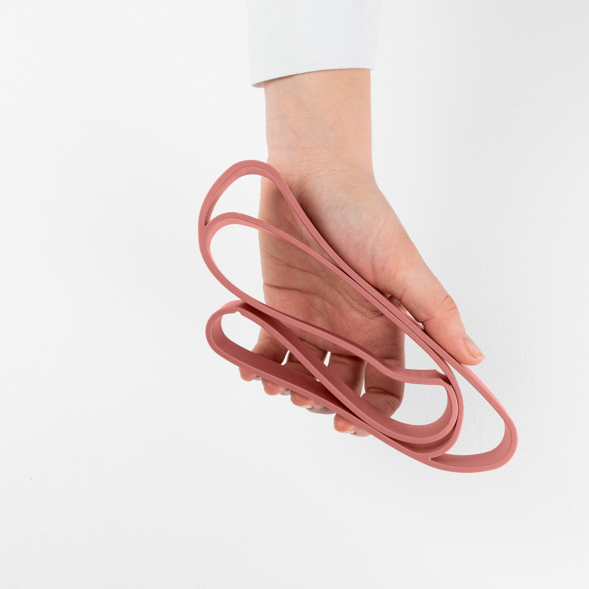 Blim+ Lunchbox Bauletto Medium with a pink elastic strap held in a hand