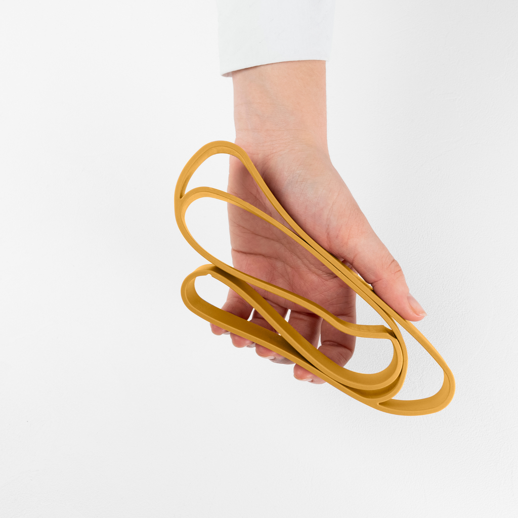 Blim+ Lunchbox Bauletto Small with a yellow elastic strap held in a hand