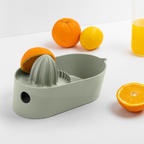 Blim+ Oblo' Juicer in green, beside fresh oranges