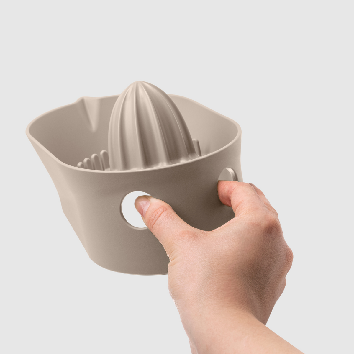 Blim+ Oblo' Juicer in taupe, held in a hand