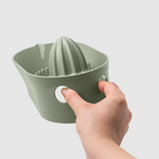 Blim+ Oblo' Juicer in green, held in a hand