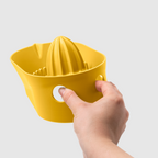 Blim+ Oblo' Juicer in yellow, held in a hand