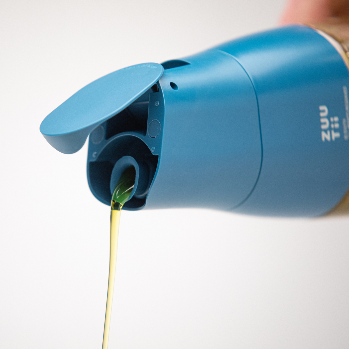 Zuutii Oil Dispenser in blue, close-up of the spout pouring oil