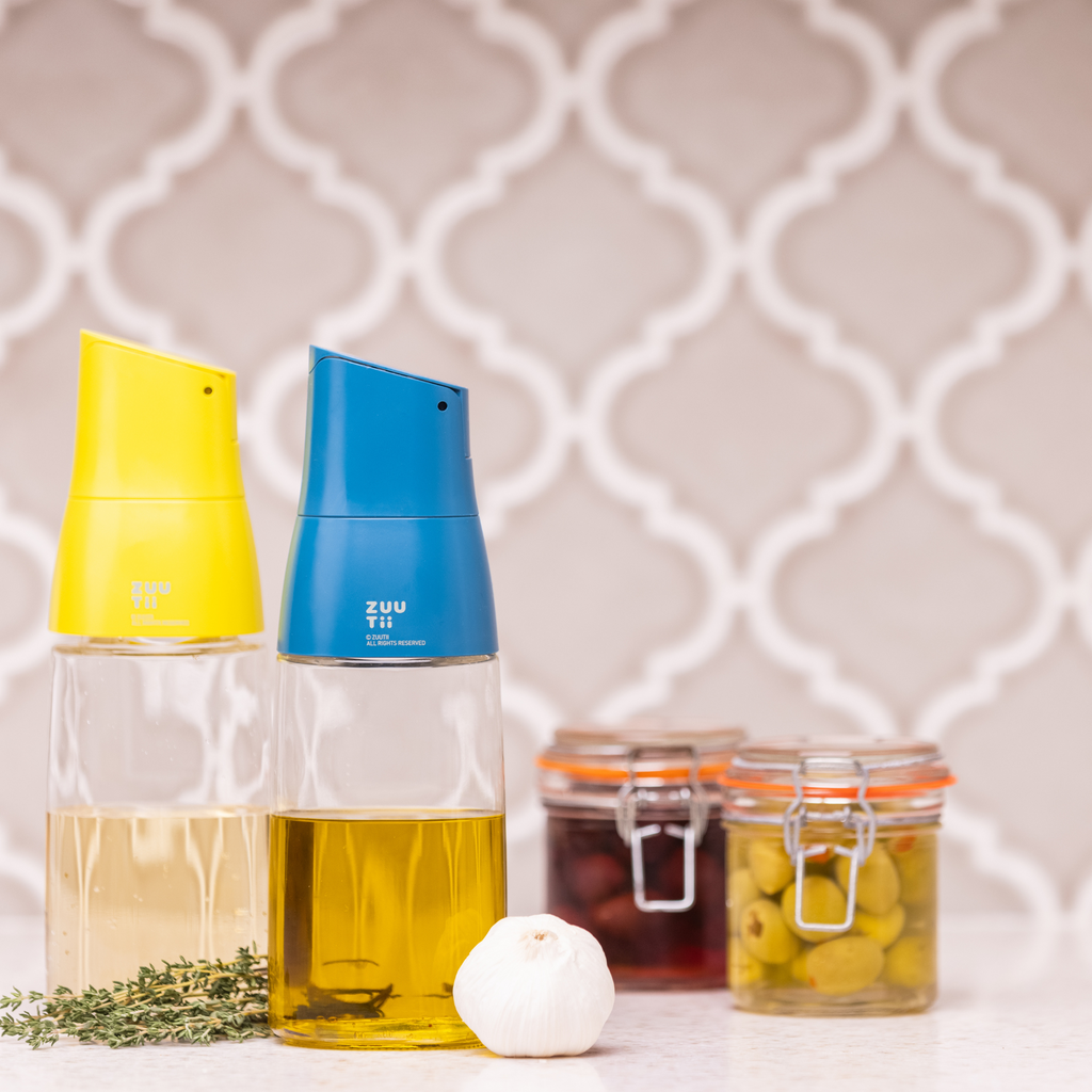 Zuutii Oil Dispenser in yellow and blue with olive oil beside small jars