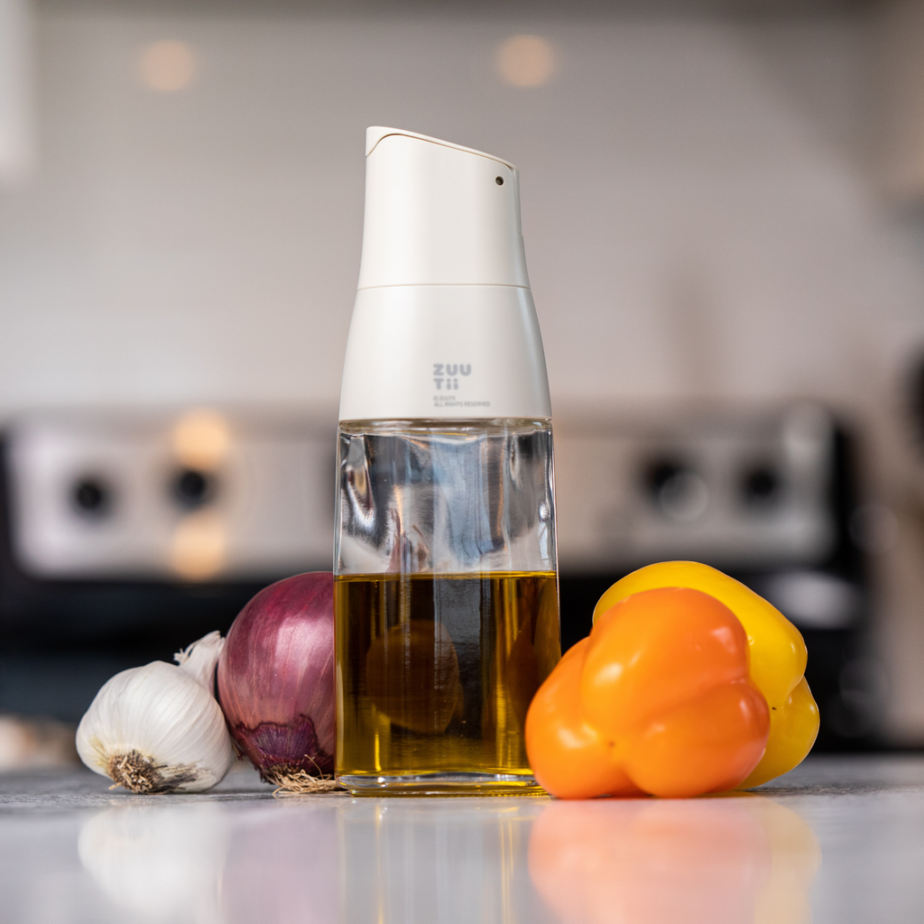 Zuutii Oil Dispenser in cream with olive oil beside vegetables