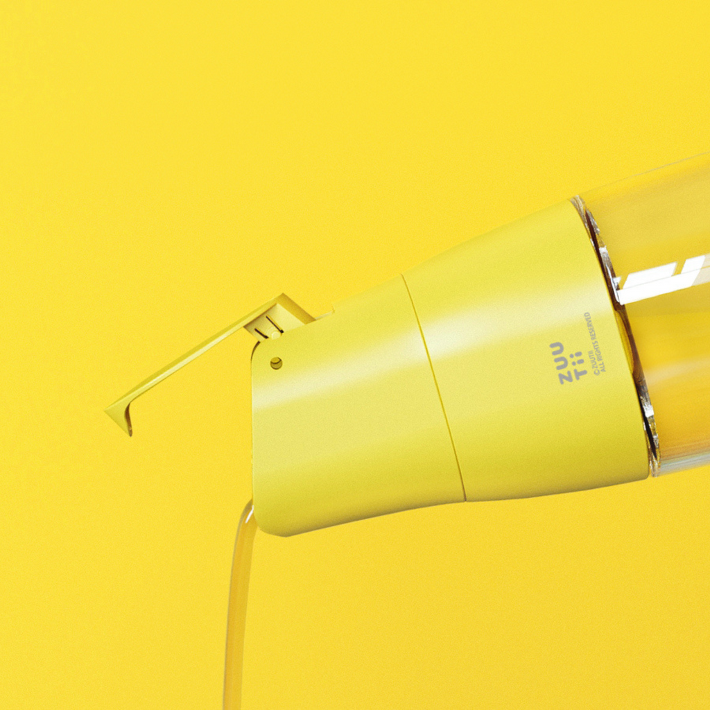 Zuutii Oil Dispenser in yellow, pouring oil against a yellow background
