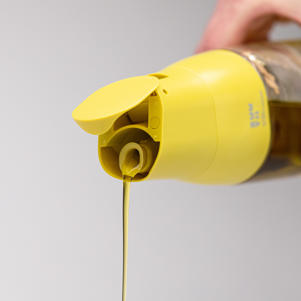 Zuutii Oil Dispenser in yellow, close-up of the spout pouring oil