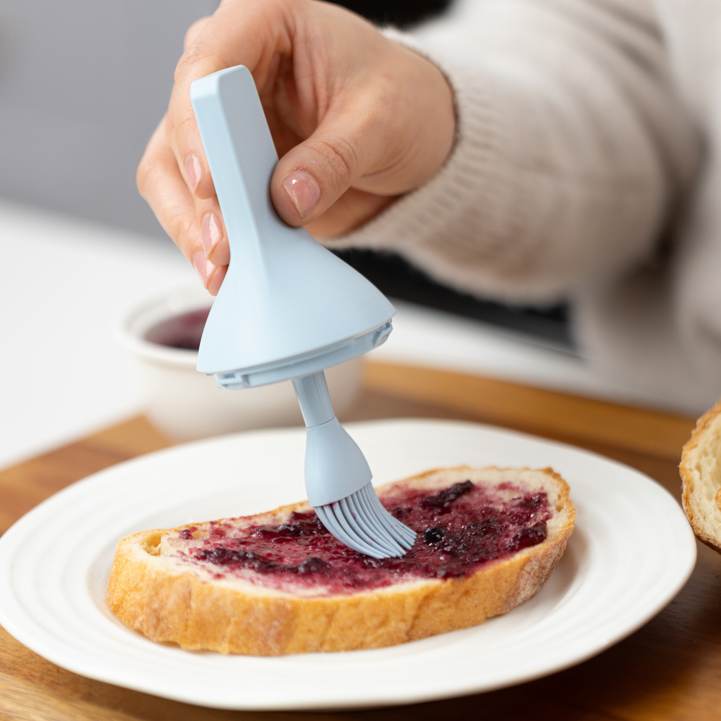 Zuutii Oil Dispenser with Brush in blue, brushing jam onto toast