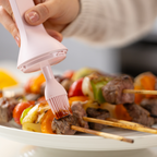 Zuutii Oil Dispenser with Brush in pink, brushing sauce over kebabs on a plate