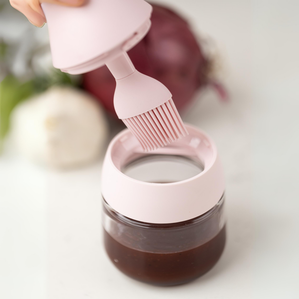Zuutii Oil Dispenser with Brush in pink with a dark sauce in the jar