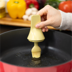 Zuutii Oil Dispenser with Brush in yellow, brushing oil in an empty red pan