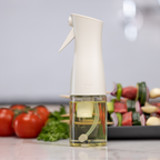 Zuutii Oil Sprayer in cream on a kitchen counter with vegetable skewers