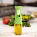 Zuutii Oil Sprayer in green on a kitchen counter beside a salad