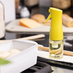 Zuutii Oil Sprayer in yellow beside a baking dish on a kitchen counter