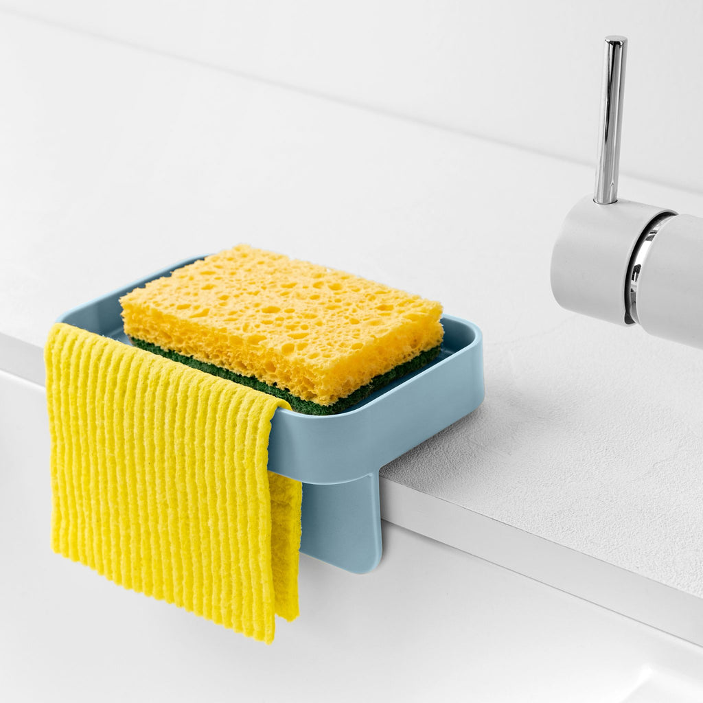 Blim+ Battigia Sponge Holder in blue holding a sponge and yellow cloth at a sink