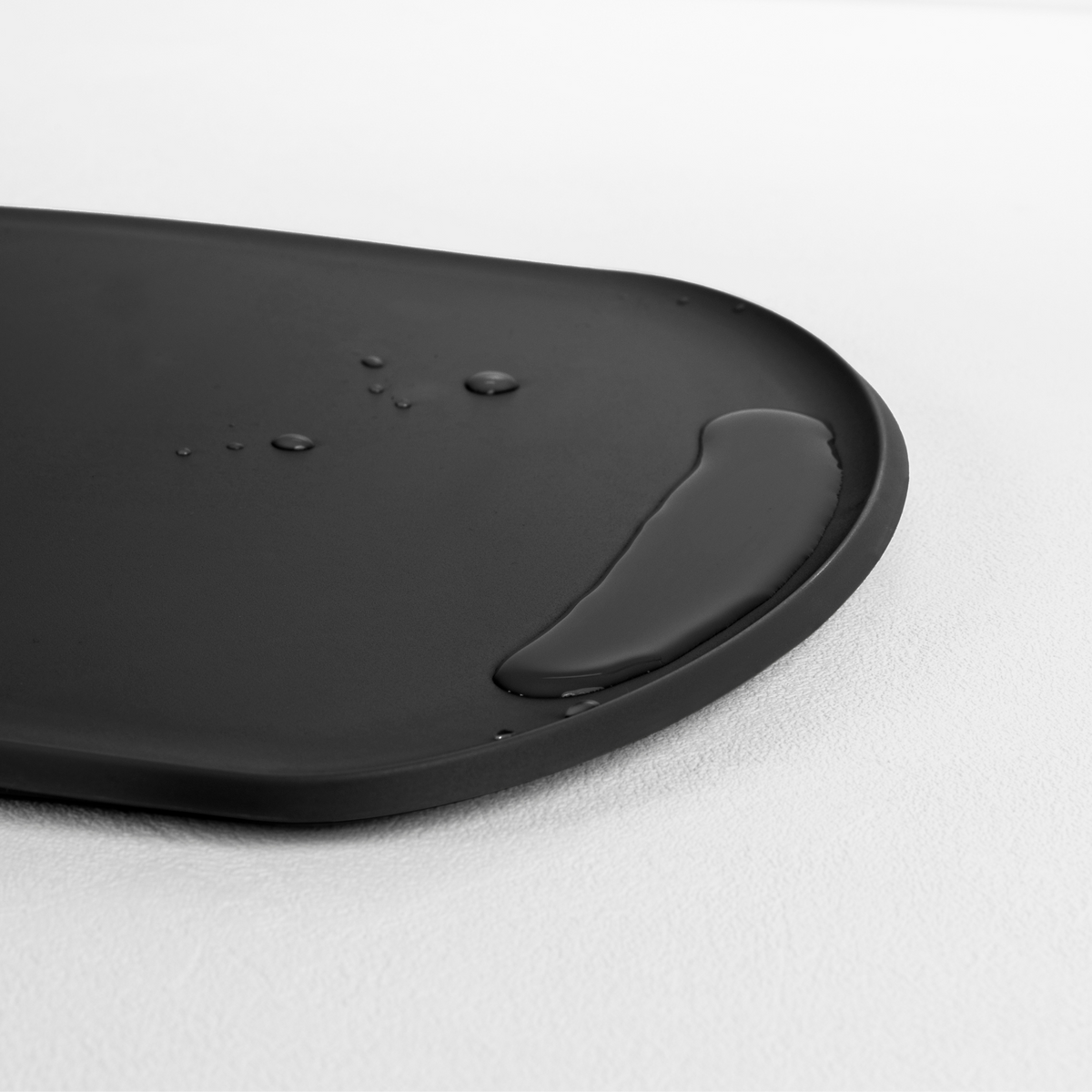 Blim+ Skateboard Chopping Board Medium in black, angled view of the raised edge