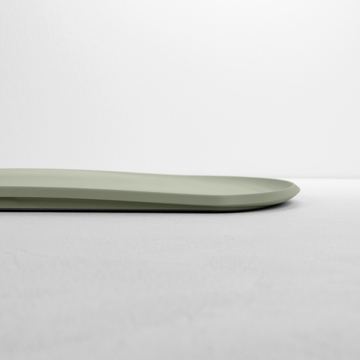 Blim+ Skateboard Chopping Board Medium in green, side view showing the thin profile