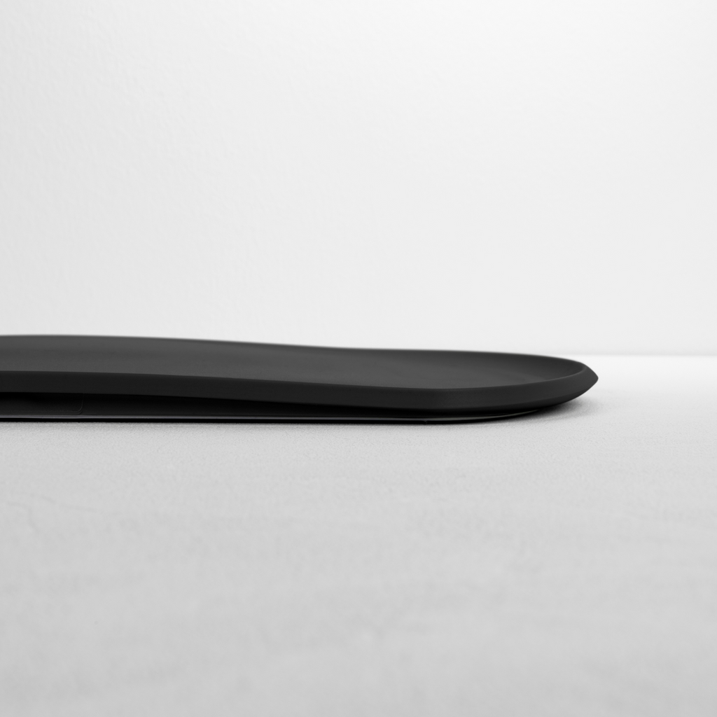Blim+ Skateboard Chopping Board Medium in black, side view showing the thin profile