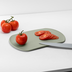 Blim+ Skateboard Chopping Board Medium in green, with sliced tomatoes and a knife