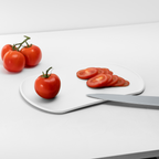 Blim+ Skateboard Chopping Board Medium in white, with sliced tomatoes and a knife