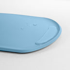 Blim+ Skateboard Chopping Board Medium in blue, angled view of the raised edge