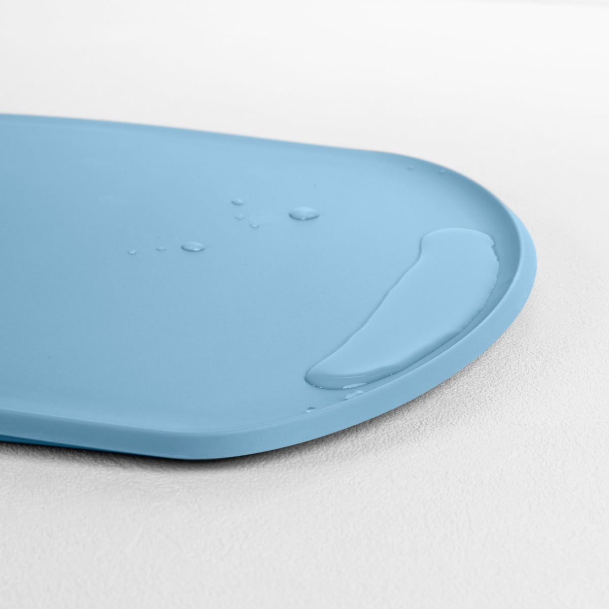 Blim+ Skateboard Chopping Board Medium in blue, angled view of the raised edge
