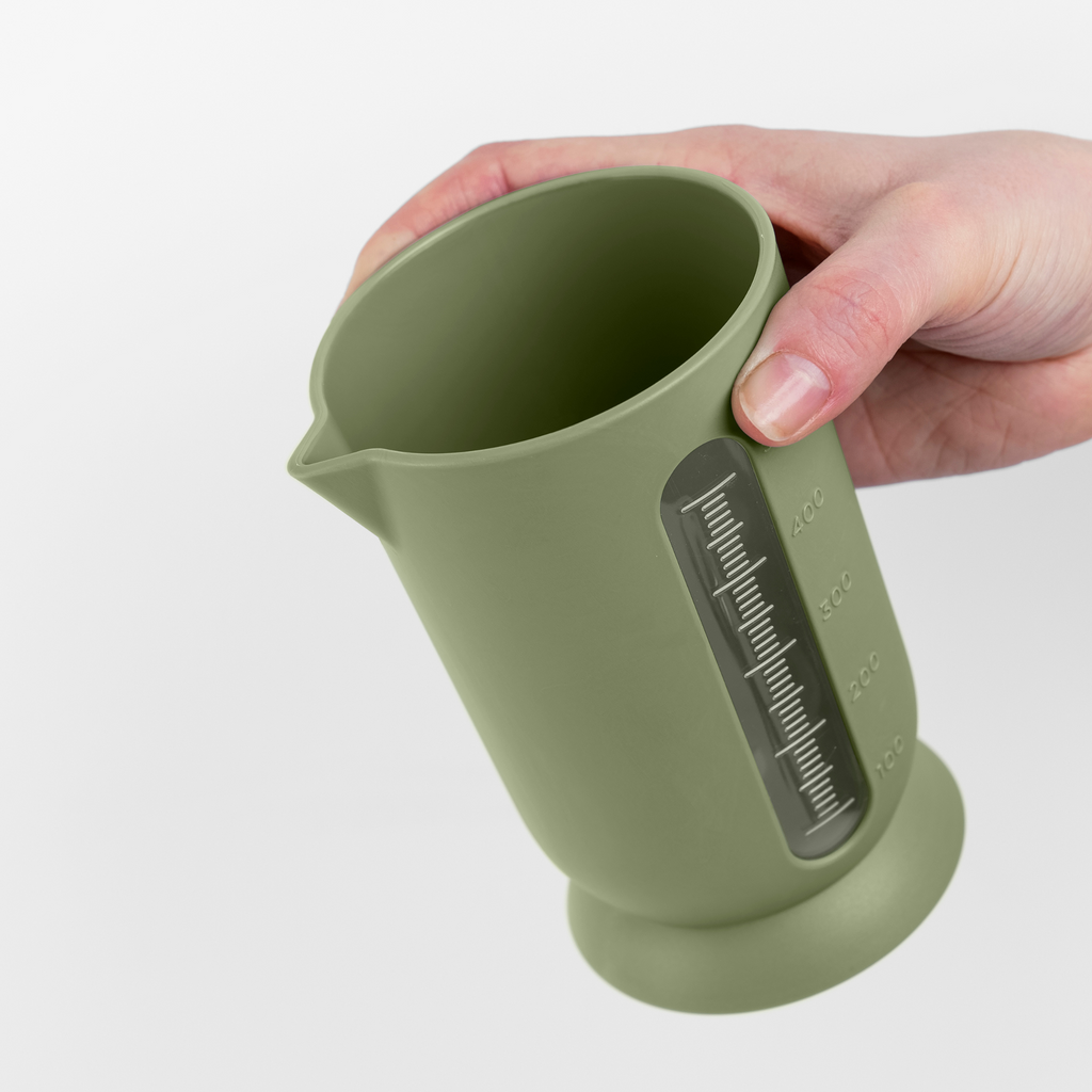 Blim+ UFO Juicer with QB Carafe in green, carafe held in a hand