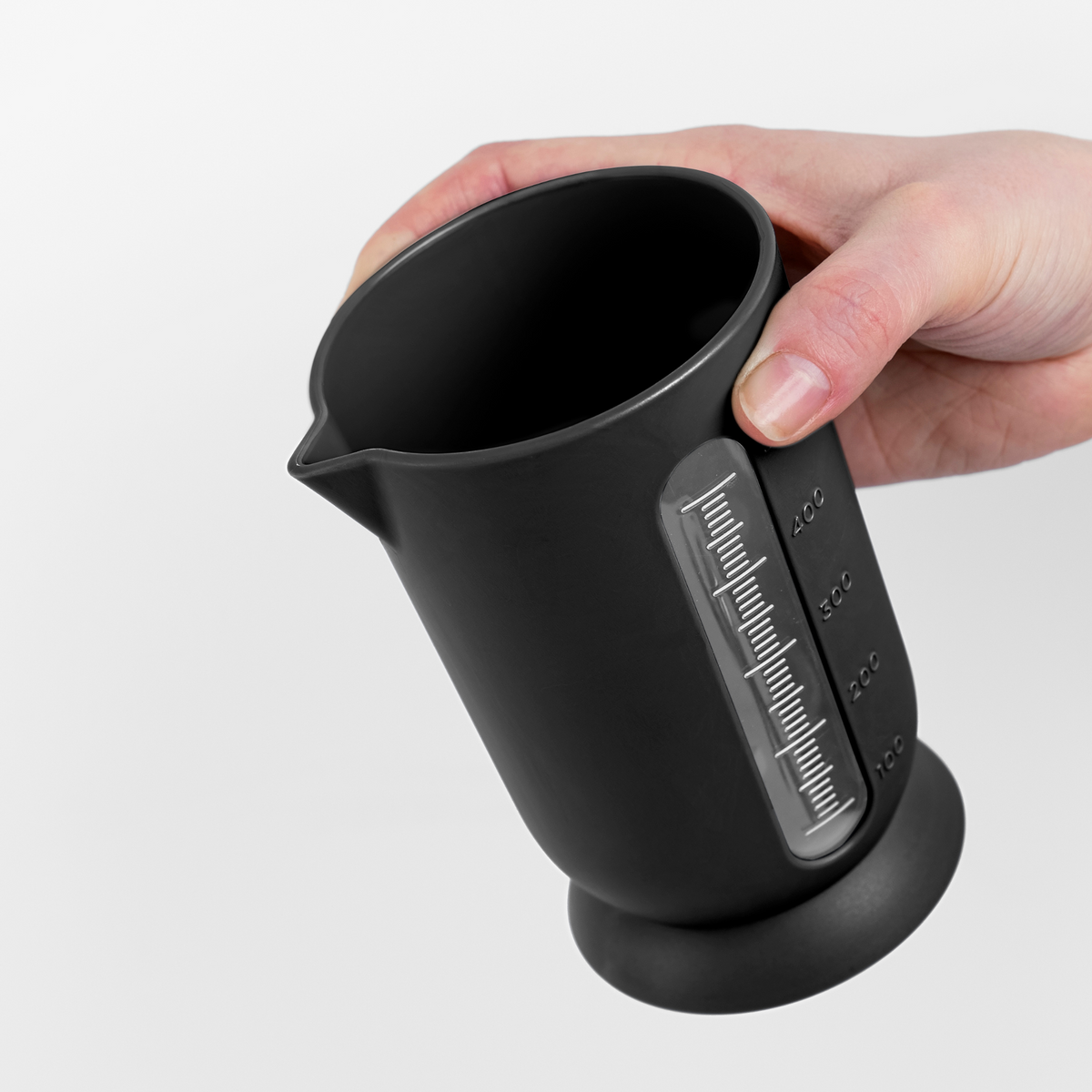 Blim+ UFO Juicer with QB Carafe in black, carafe held in a hand