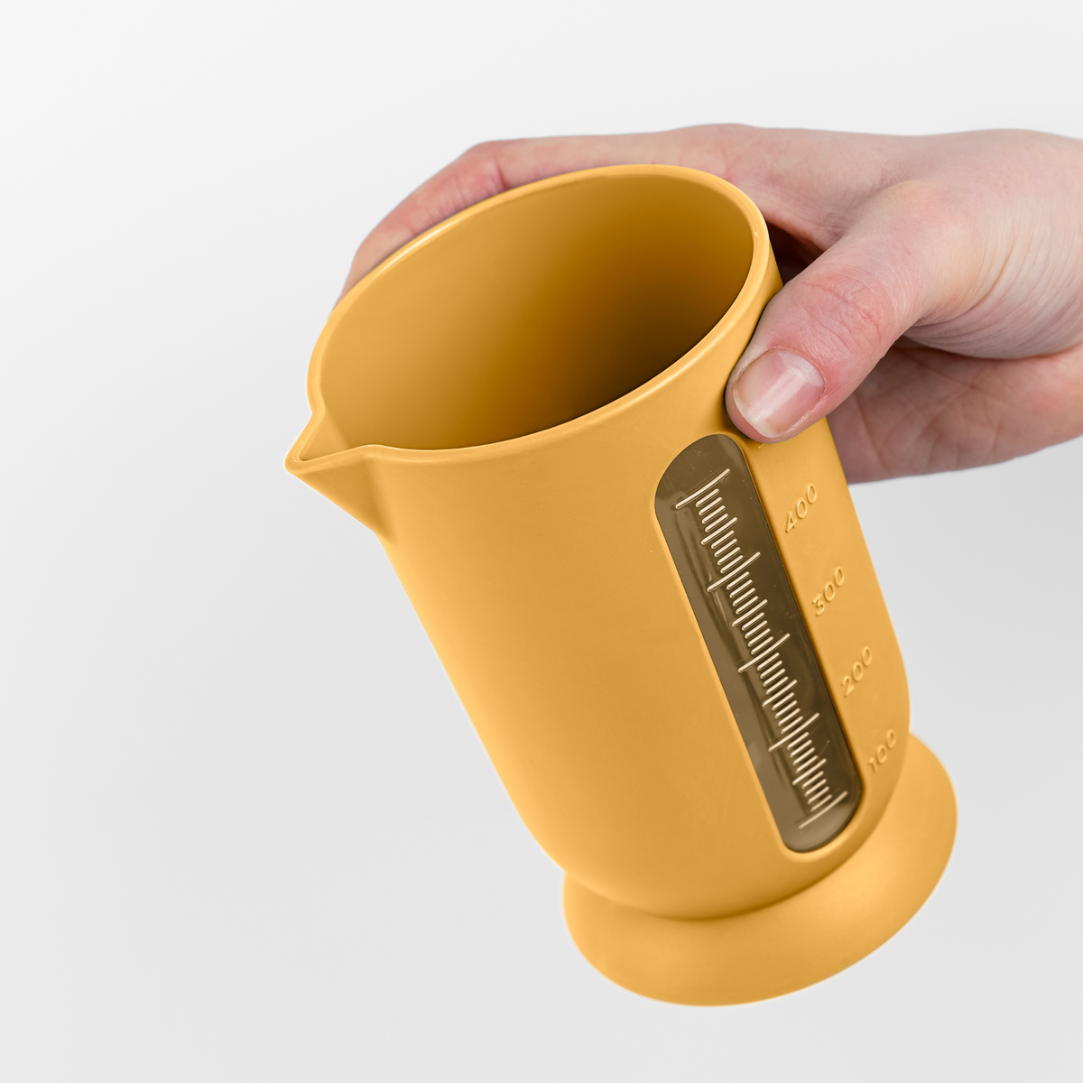 Blim+ UFO Juicer with QB Carafe in yellow, carafe held in a hand