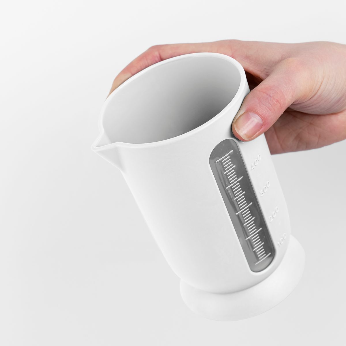 Blim+ UFO Juicer with QB Carafe in white, carafe held in a hand
